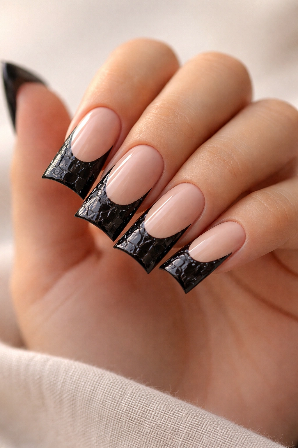 Close-up of nude base nails with black croc texture on the tips