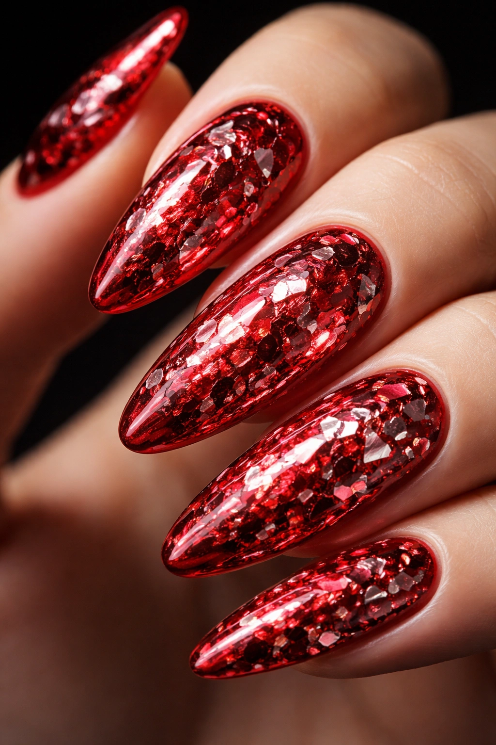Close-up of a red oval nail with crushed mirror texture
