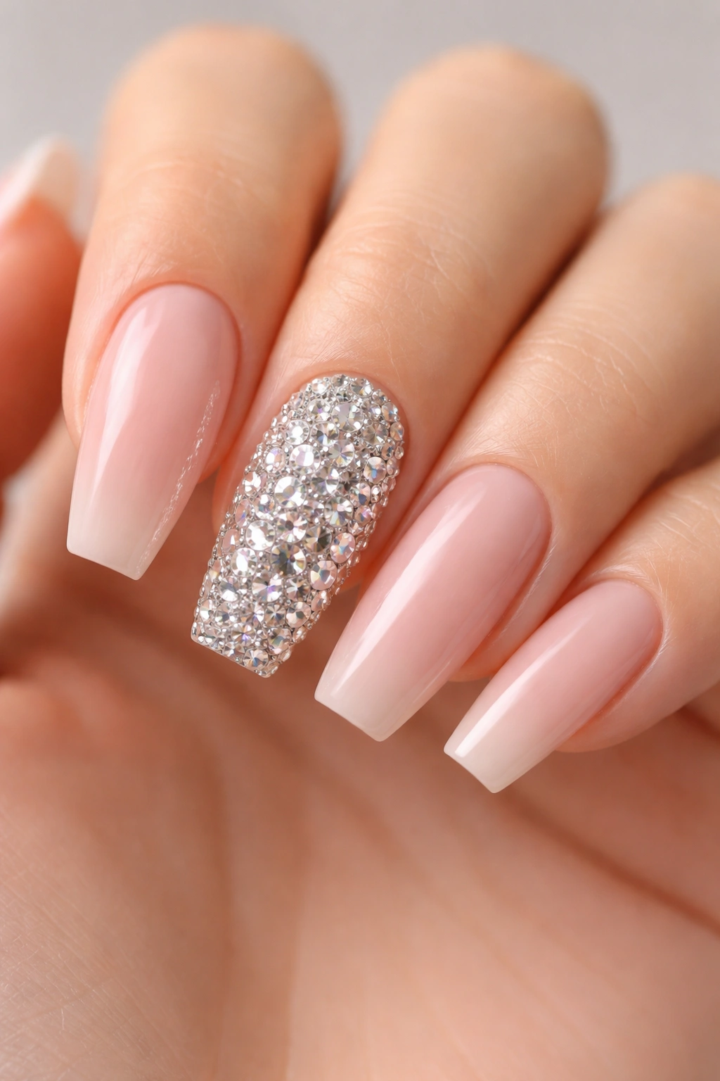 Close-up of hand with full crystal ring-finger accent on nude nails
