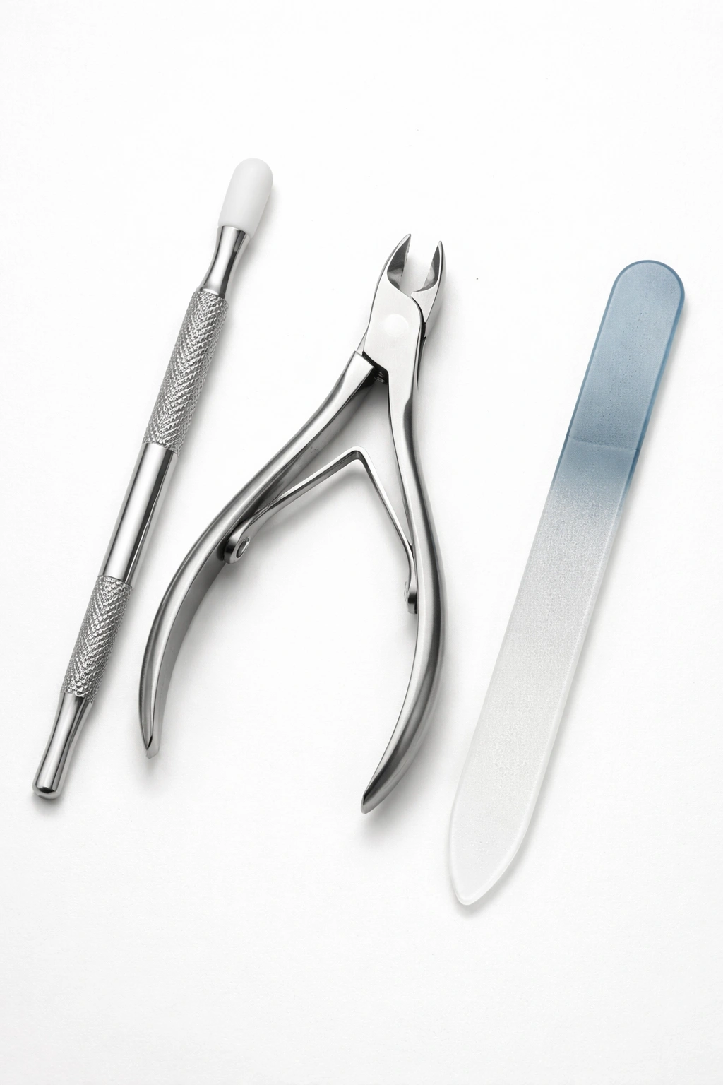 Three cuticle care tools arranged on a plain background