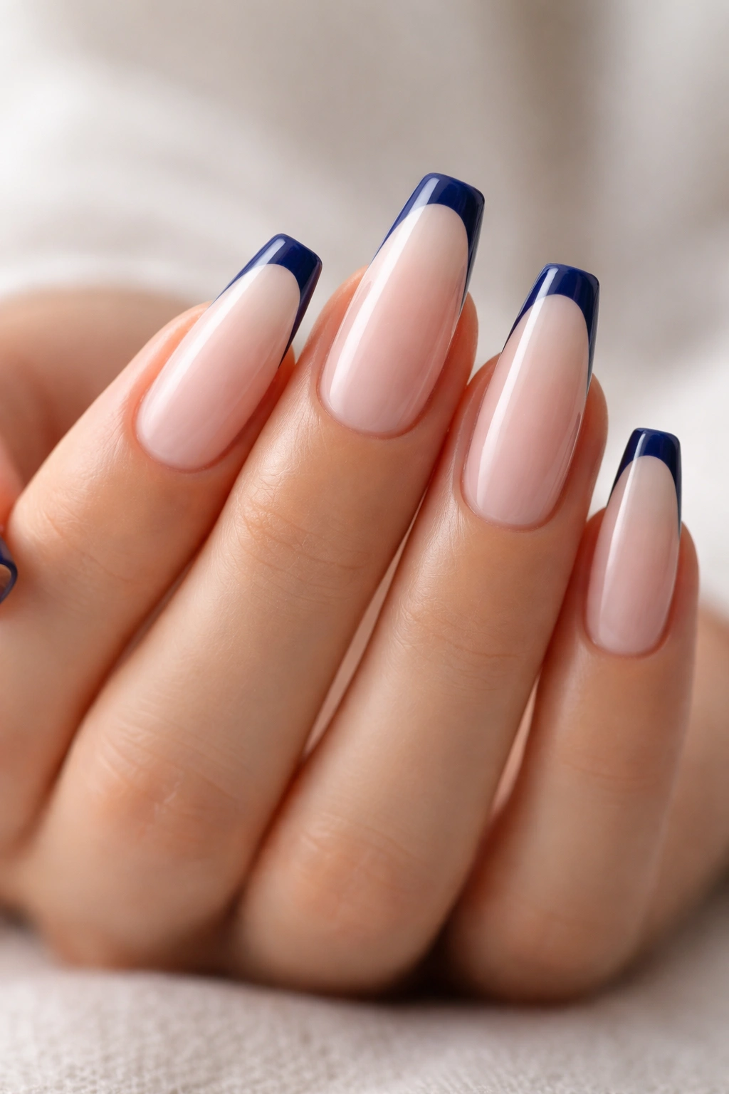 Dark blue micro-French nails on milky nude base