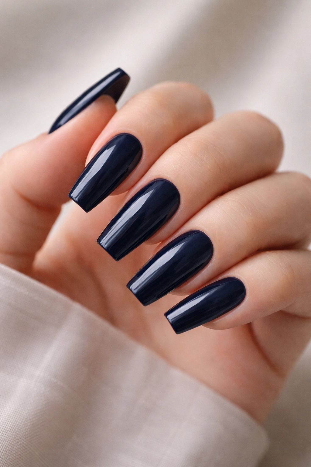 Close-up of deep navy ballerina nails with a glossy finish and crisp square tips