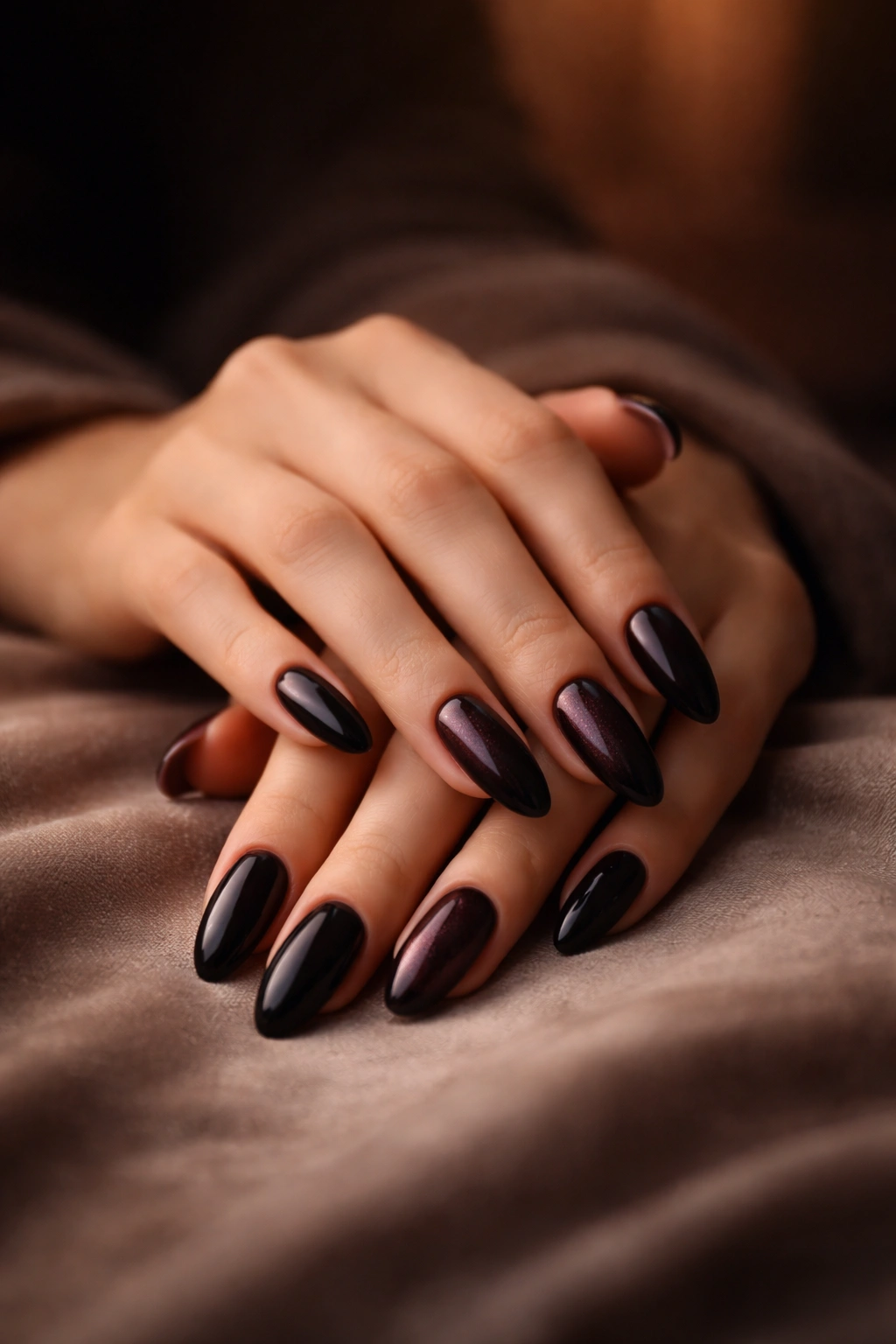Close-up of hands with moody dark nails in a calm, reflective setting