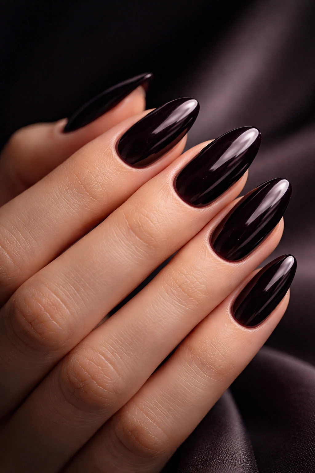 Close-up of deep glossy nails on a hand with a soft background