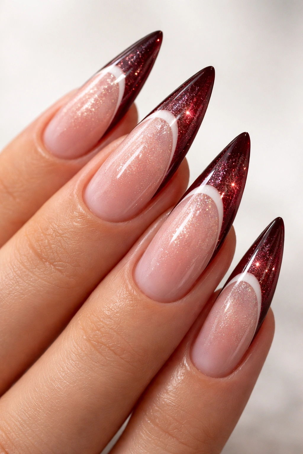 Dark red stiletto nails with pearl champagne shimmer