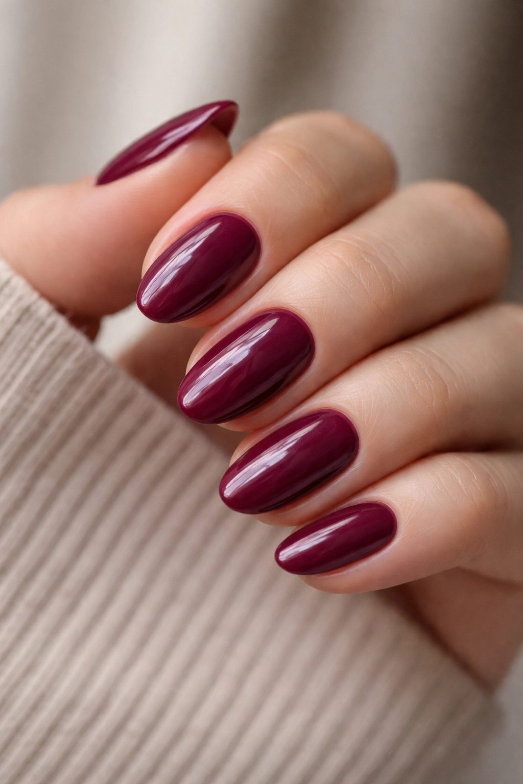 Close-up of deep berry nails on short almond shape