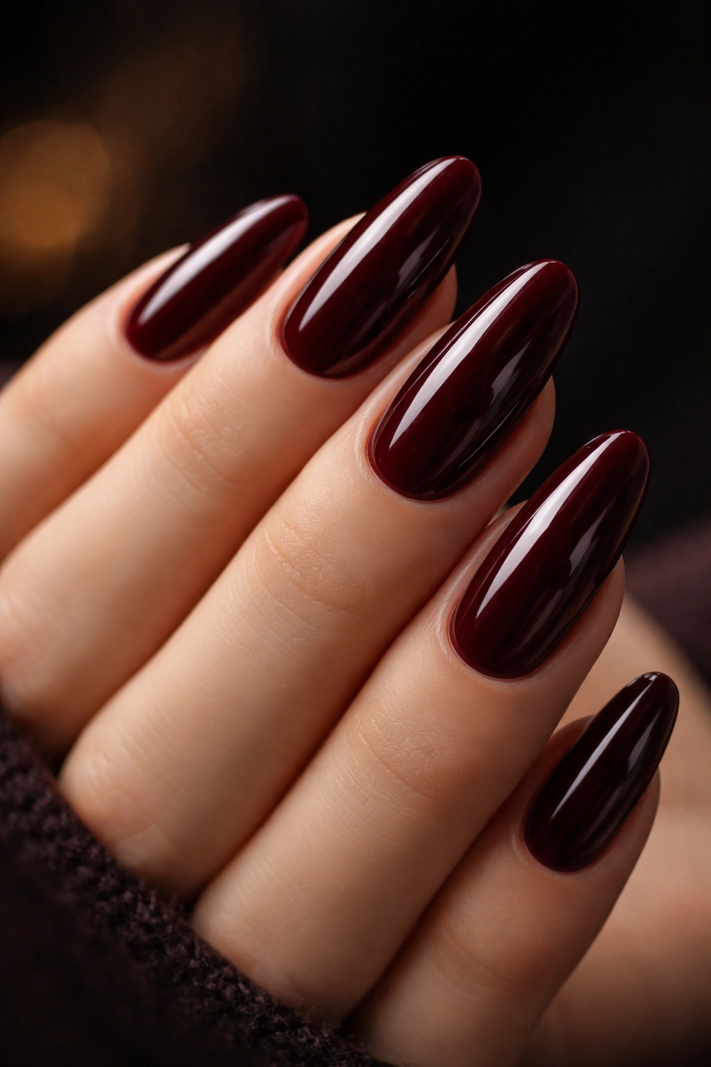 Long oval nails in deep burgundy with high shine.