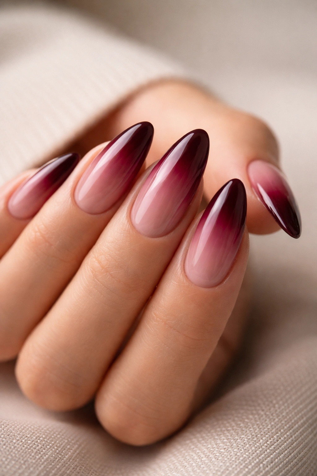 Almond nails with deep burgundy tips on nude base