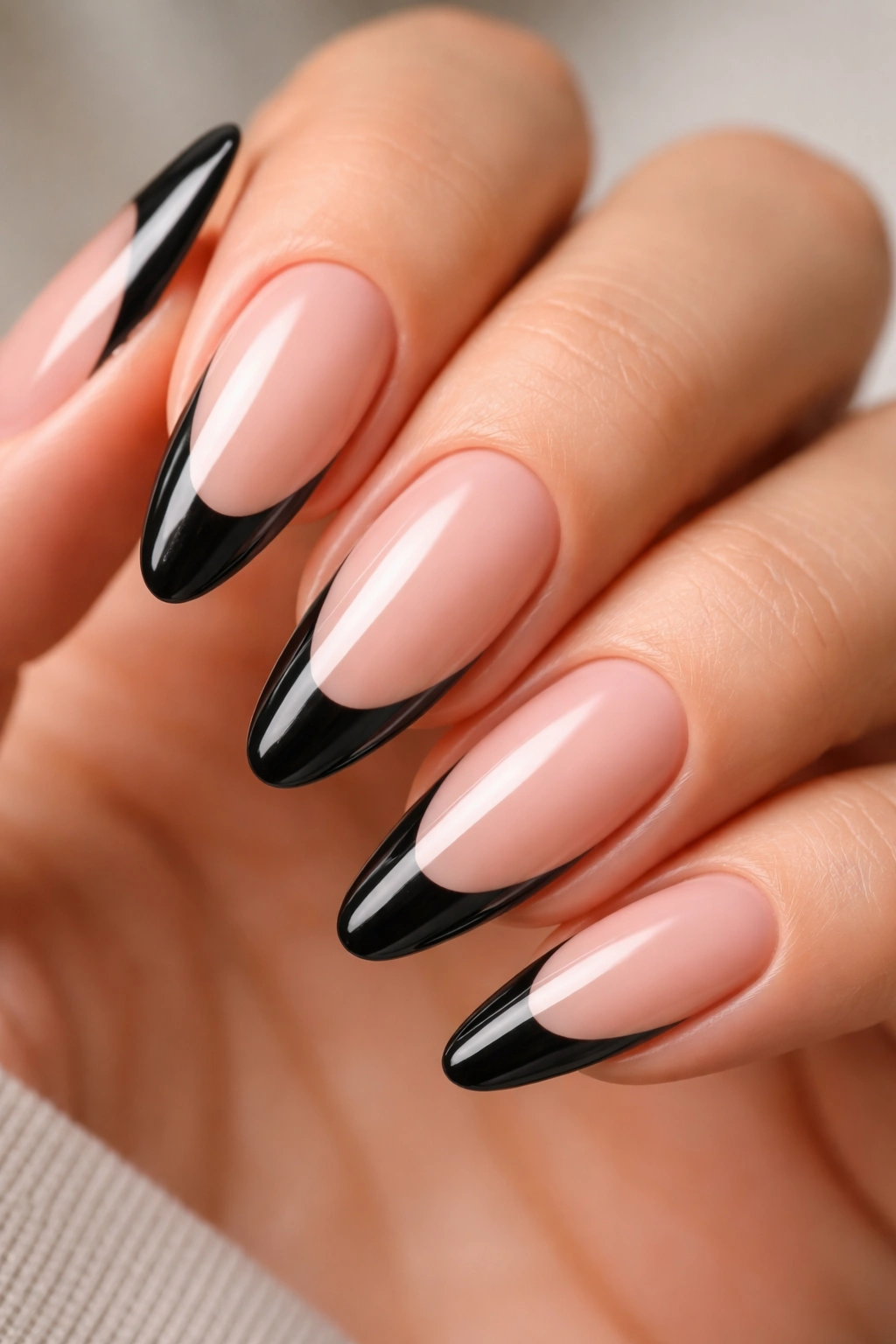 Close-up of an almond nail with a deep curved black French tip.