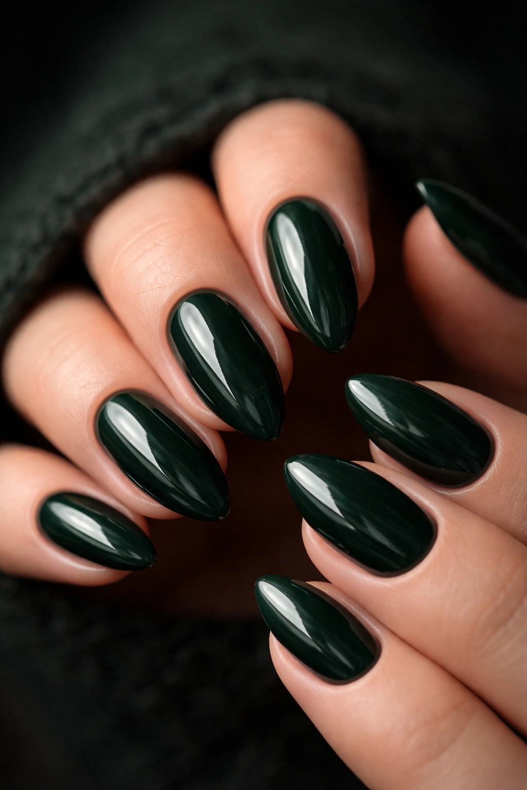 Short almond nails in deep forest green with a glossy finish
