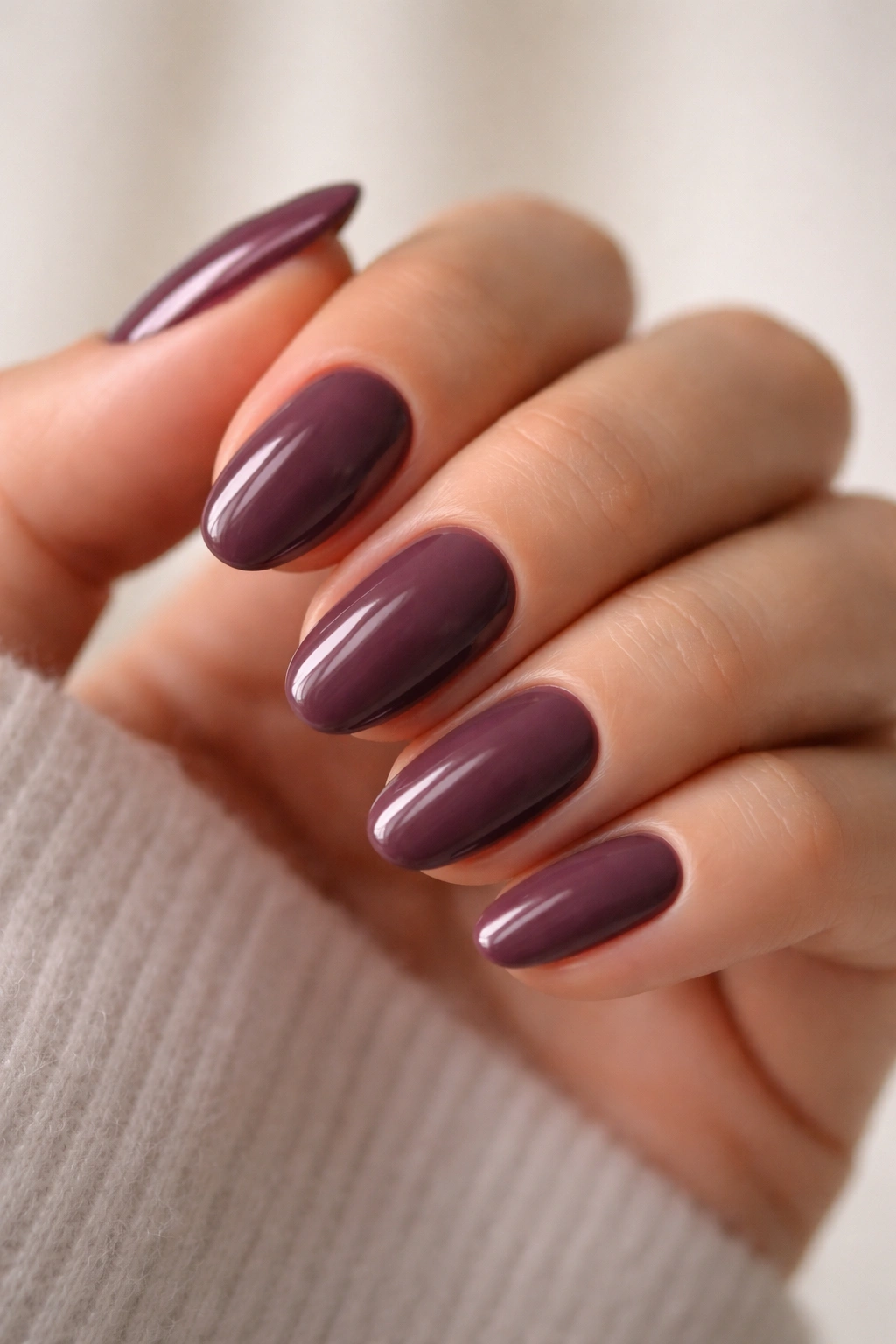 Close-up of deep mauve noir nails on short almond shape