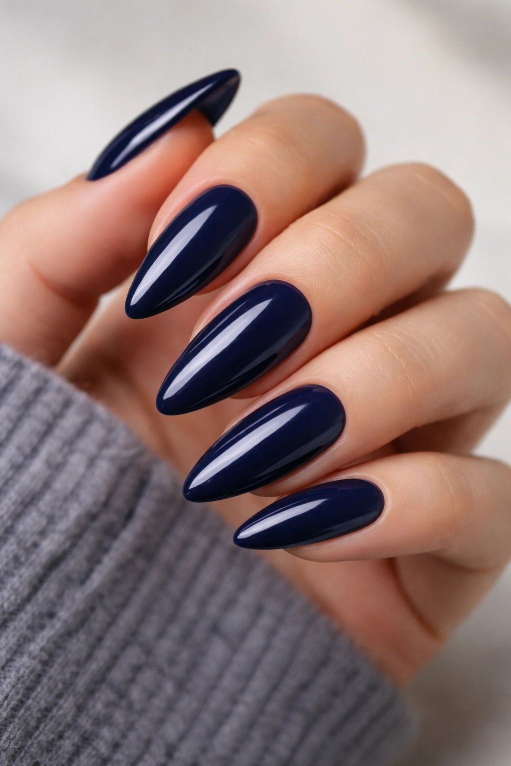 Close-up of deep navy almond nails with glossy finish