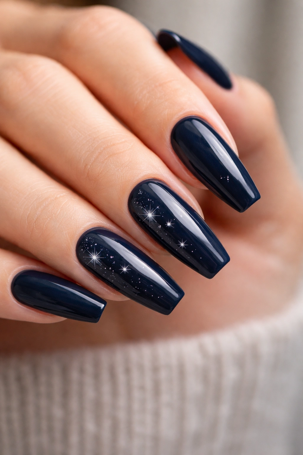 Deep navy nails with tiny starburst accents on ballerina nails