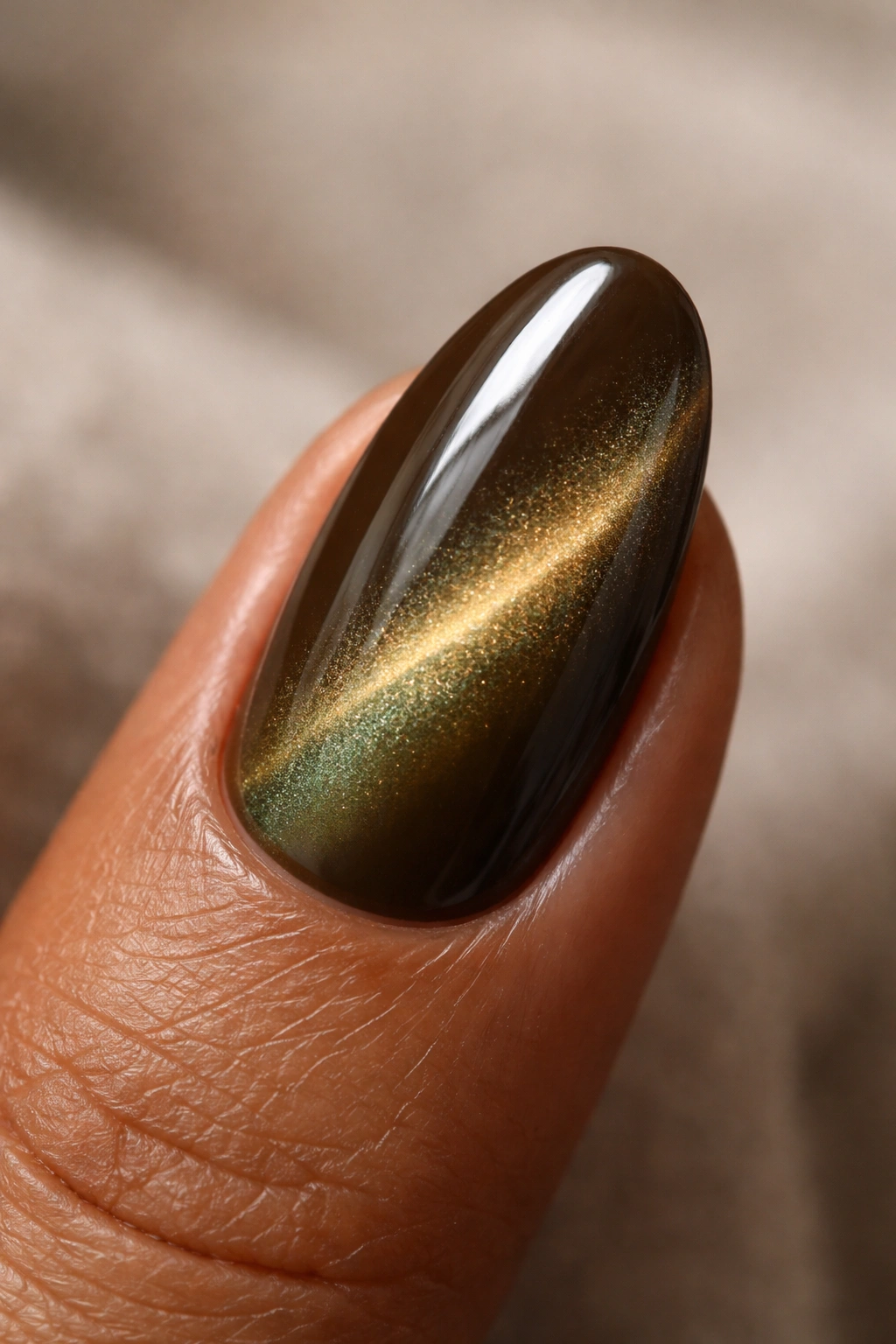 Close-up of a short almond nail in olive cat-eye shade with shimmer line