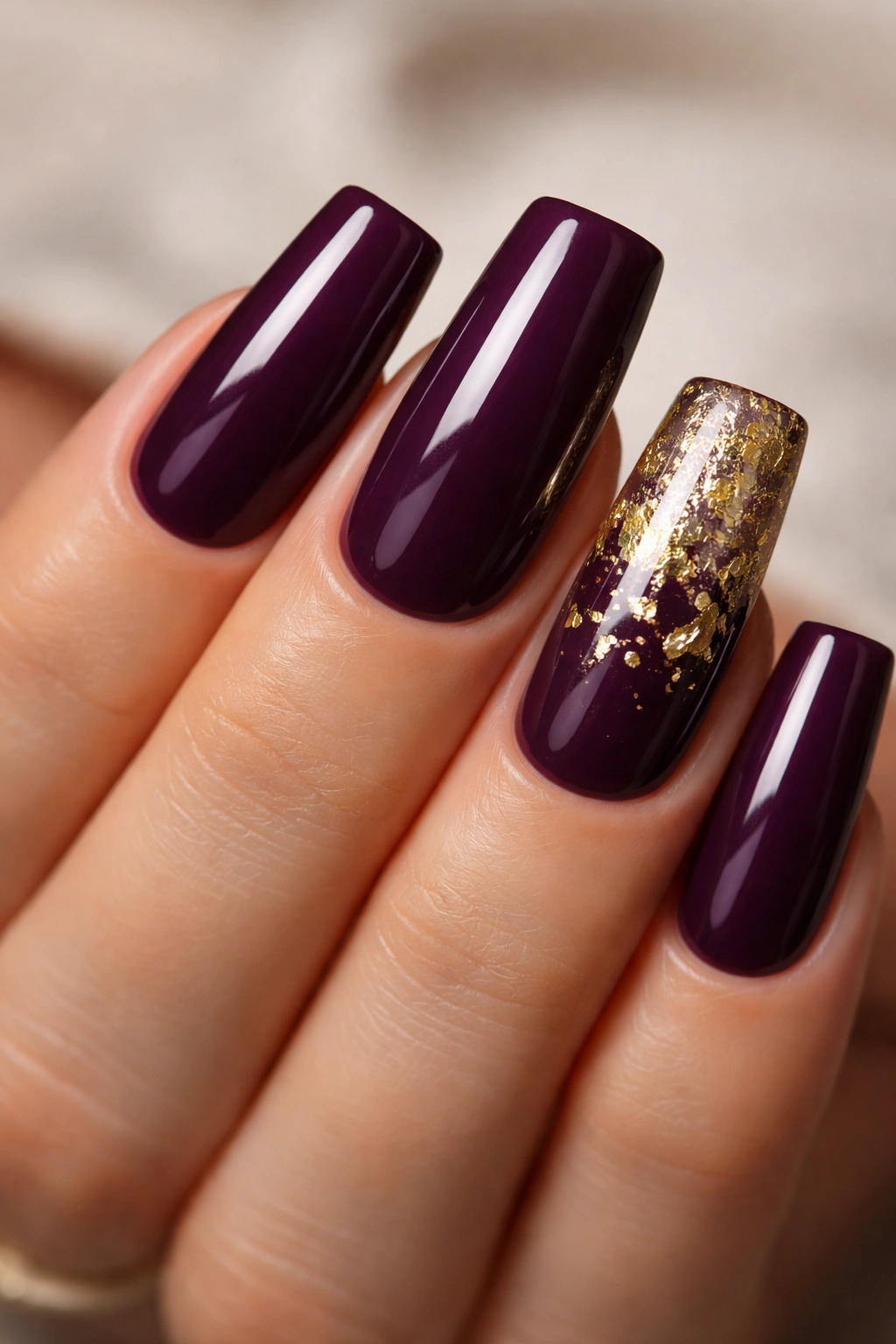 Duck nails in deep plum with one gold foil accent nail