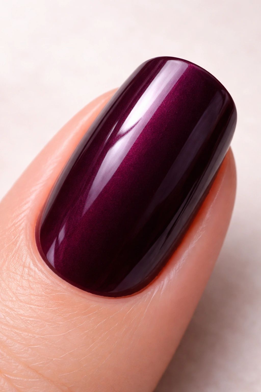 Close-up of deep plum nail with rich purple-burgundy hue and glossy finish