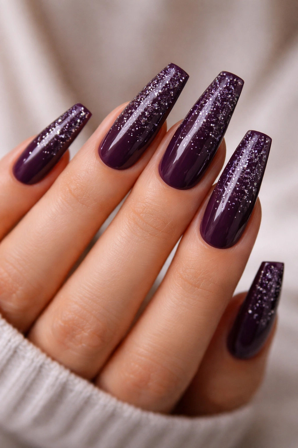 Deep plum nails with scattered silver glitter sparkle.
