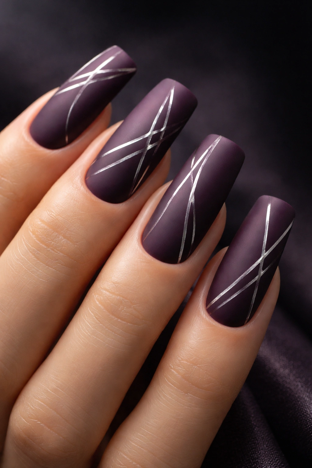 Nails in matte deep plum with silver geometric line work