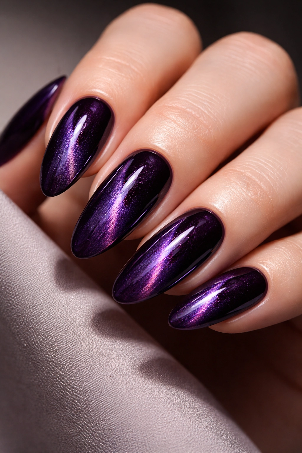 Deep purple cat-eye nails with a glowing central stripe