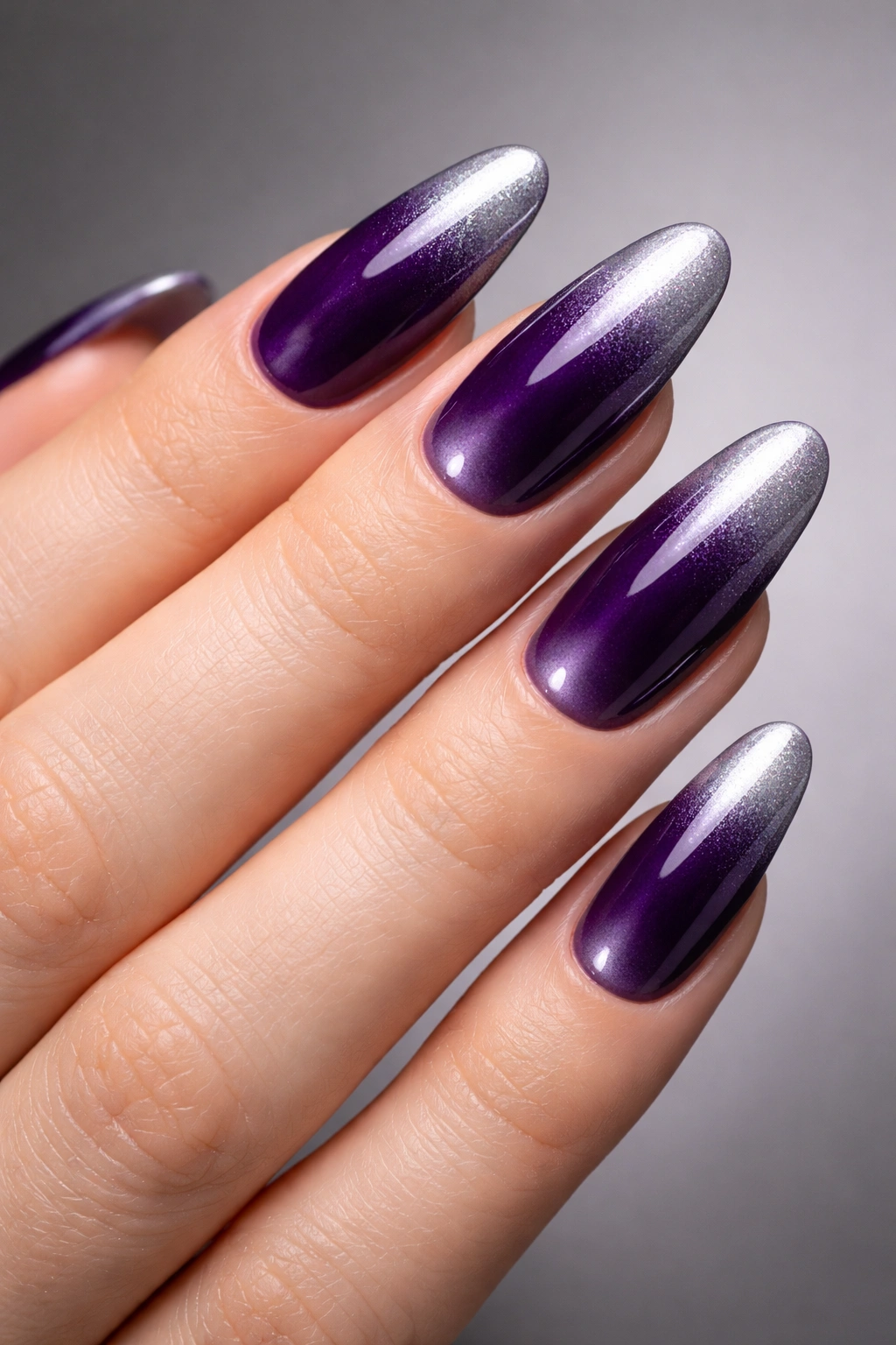 Long oval nails showing deep purple to silver ombre with a glossy sheen