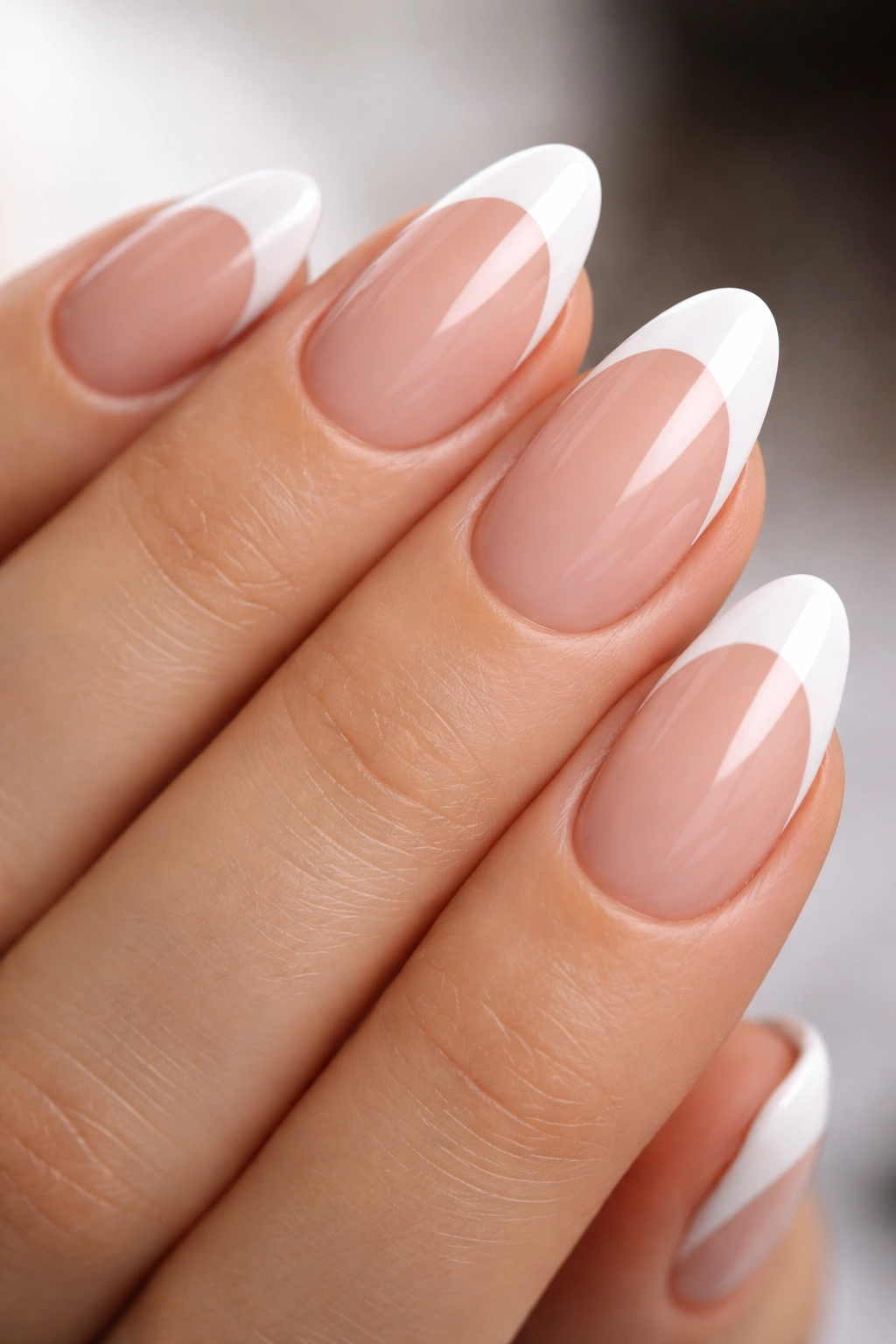 Short almond nails with a deep curved white smile line on nude base