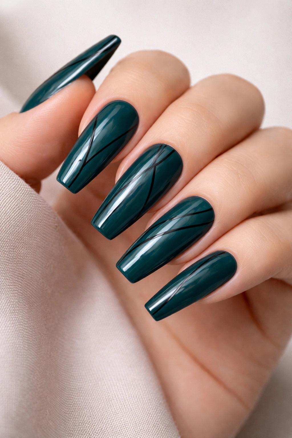 Close-up of deep teal coffin nails with ultra-thin black lines forming geometric patterns on long coffin shapes