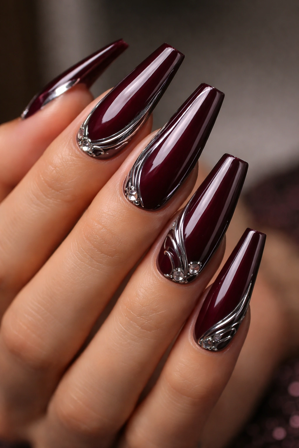 Close-up of deep wine burgundy coffin nails with chrome details