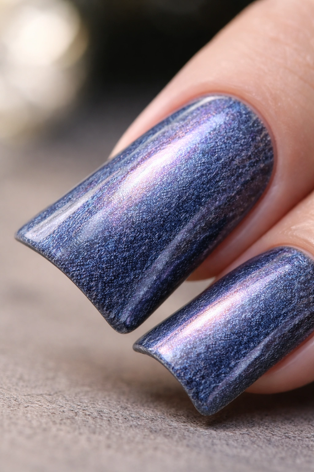 Close-up of a duck nail with denim base and iridescent pearl finish showing subtle shimmer