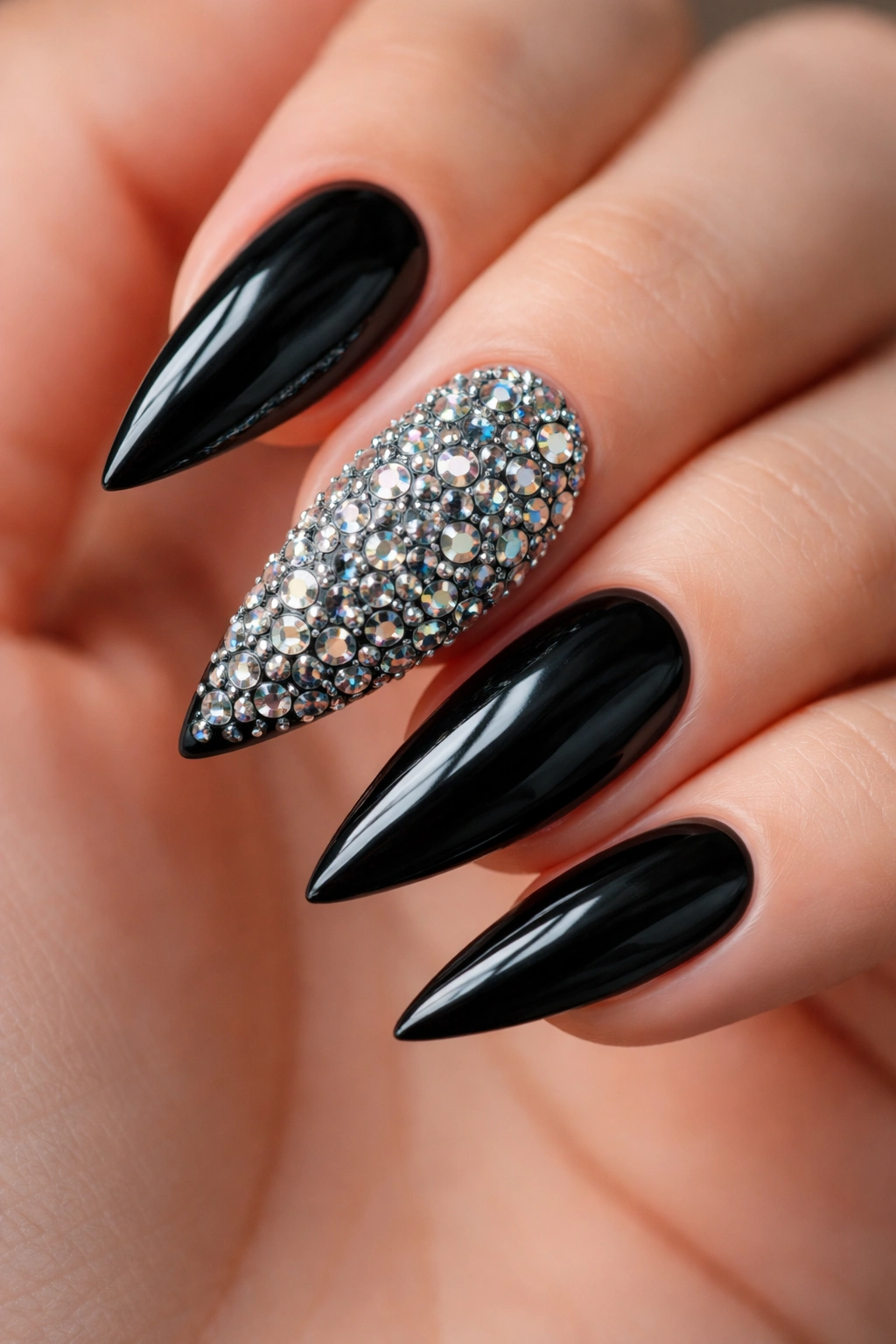 Black stiletto hand with a fully rhinestone-dense accent nail among black nails