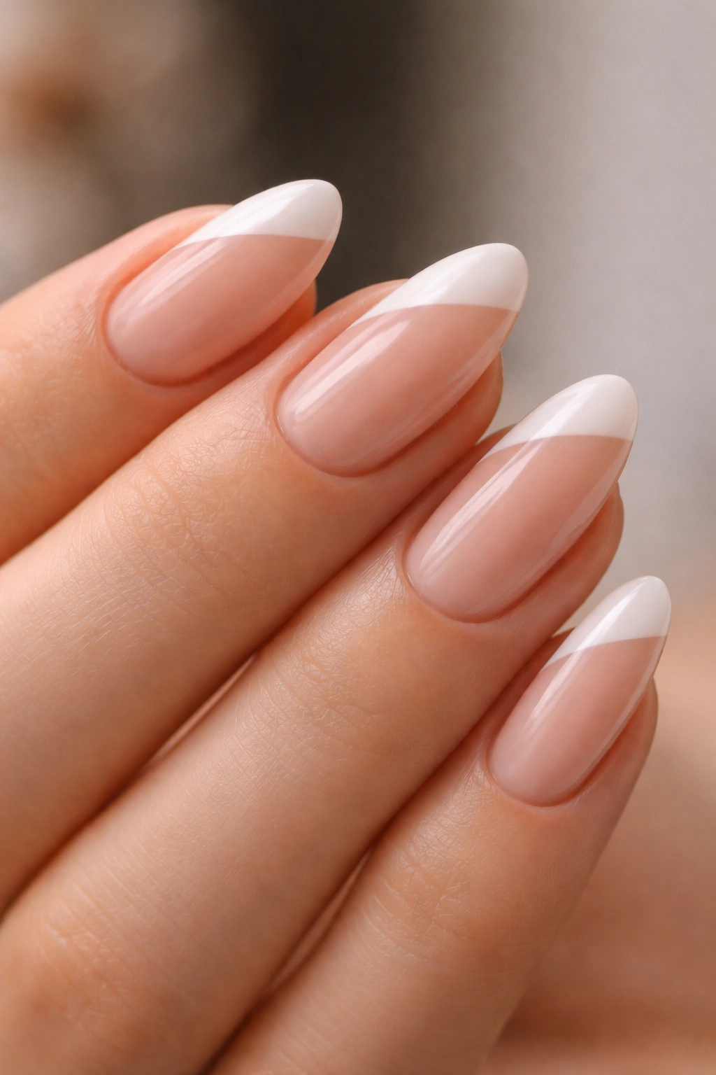 Close-up of short almond nails with diagonal French tips