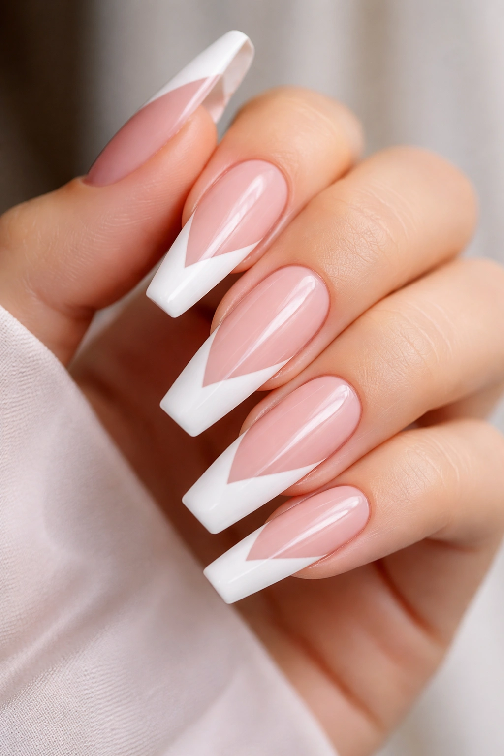 Close-up of long ballerina nails with diagonal white tips on nude base