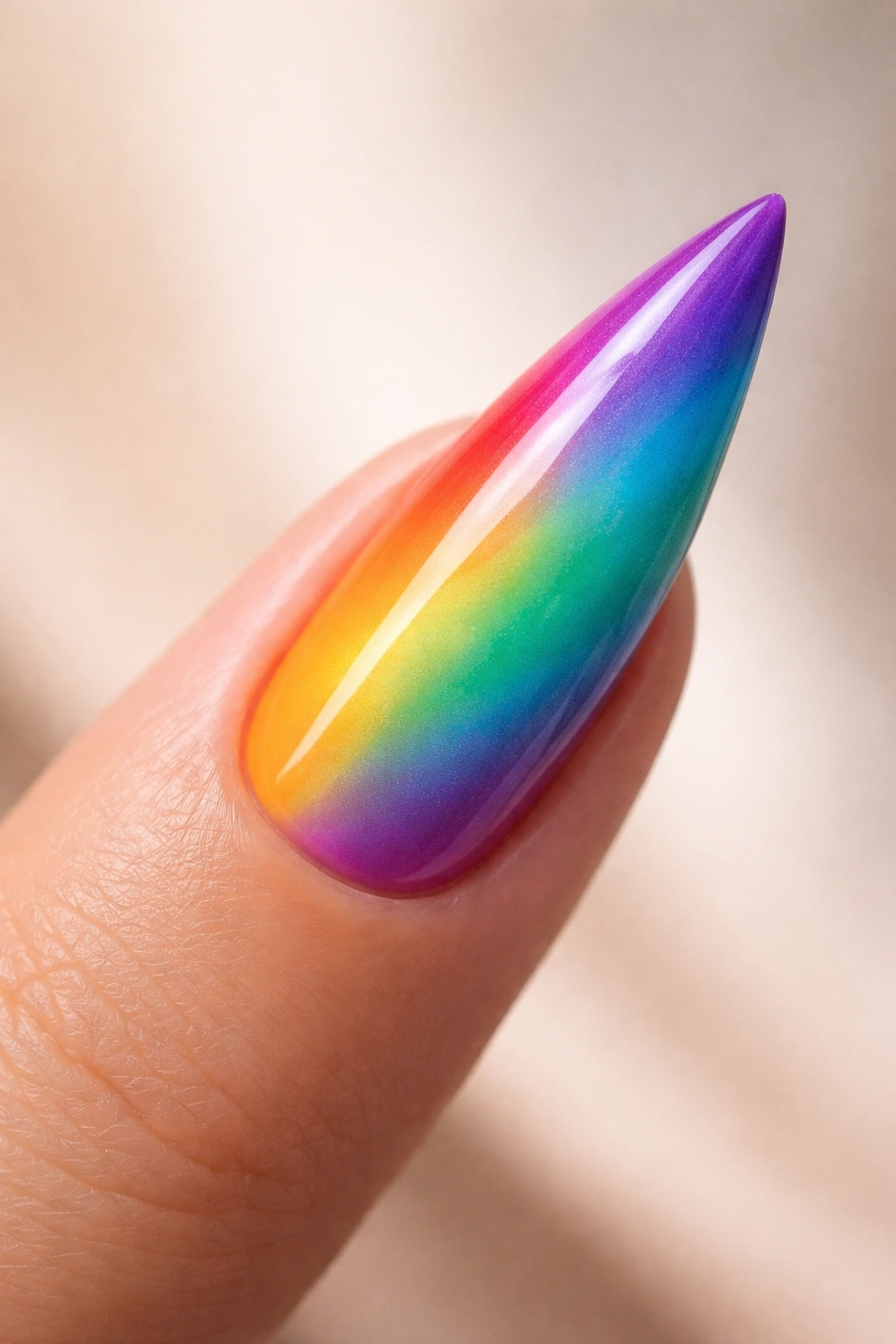 Stiletto nail with diagonal rainbow gradient from bottom-left to top-right on neutral background