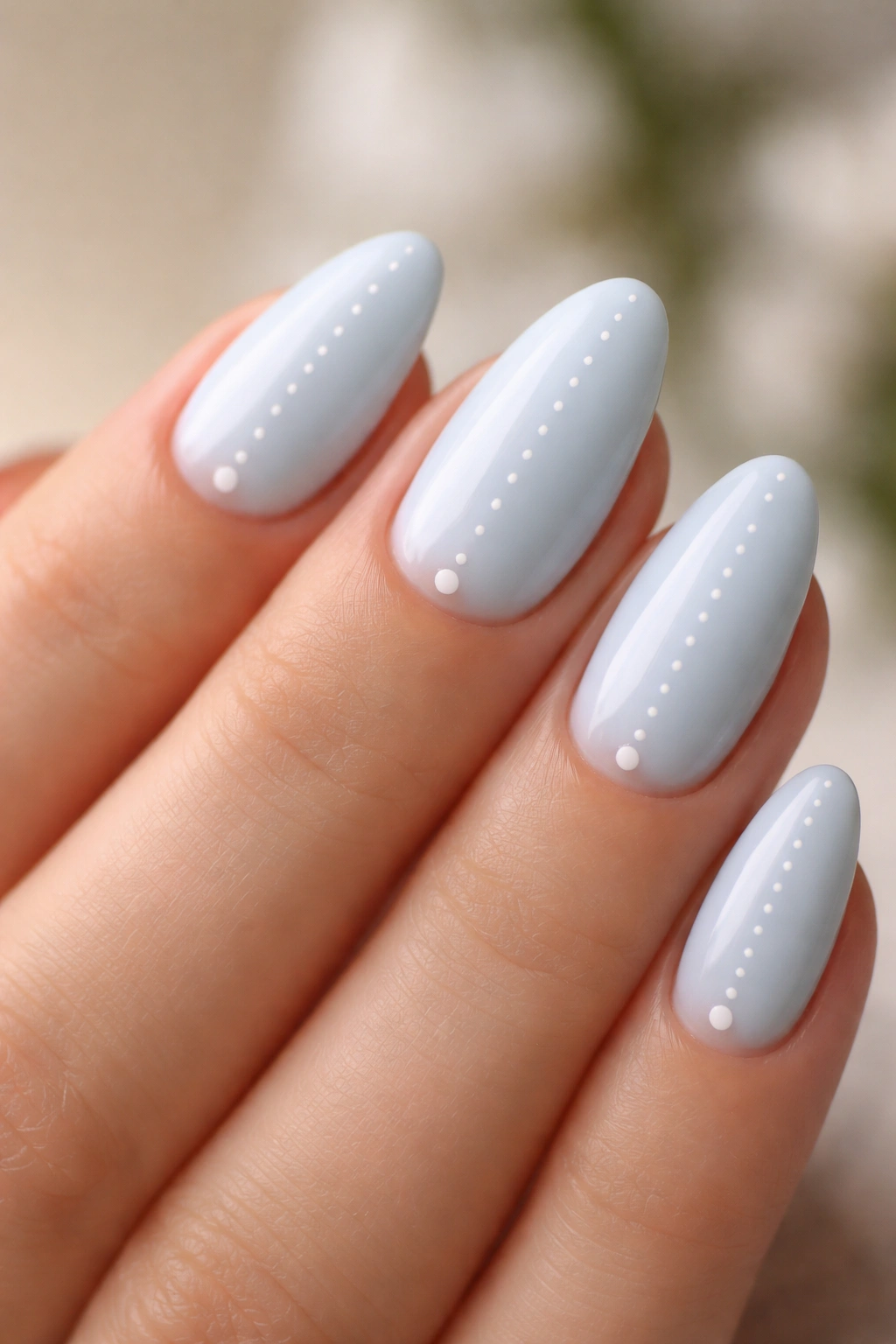 Short almond nails with pale blue polish and tiny white dot accents