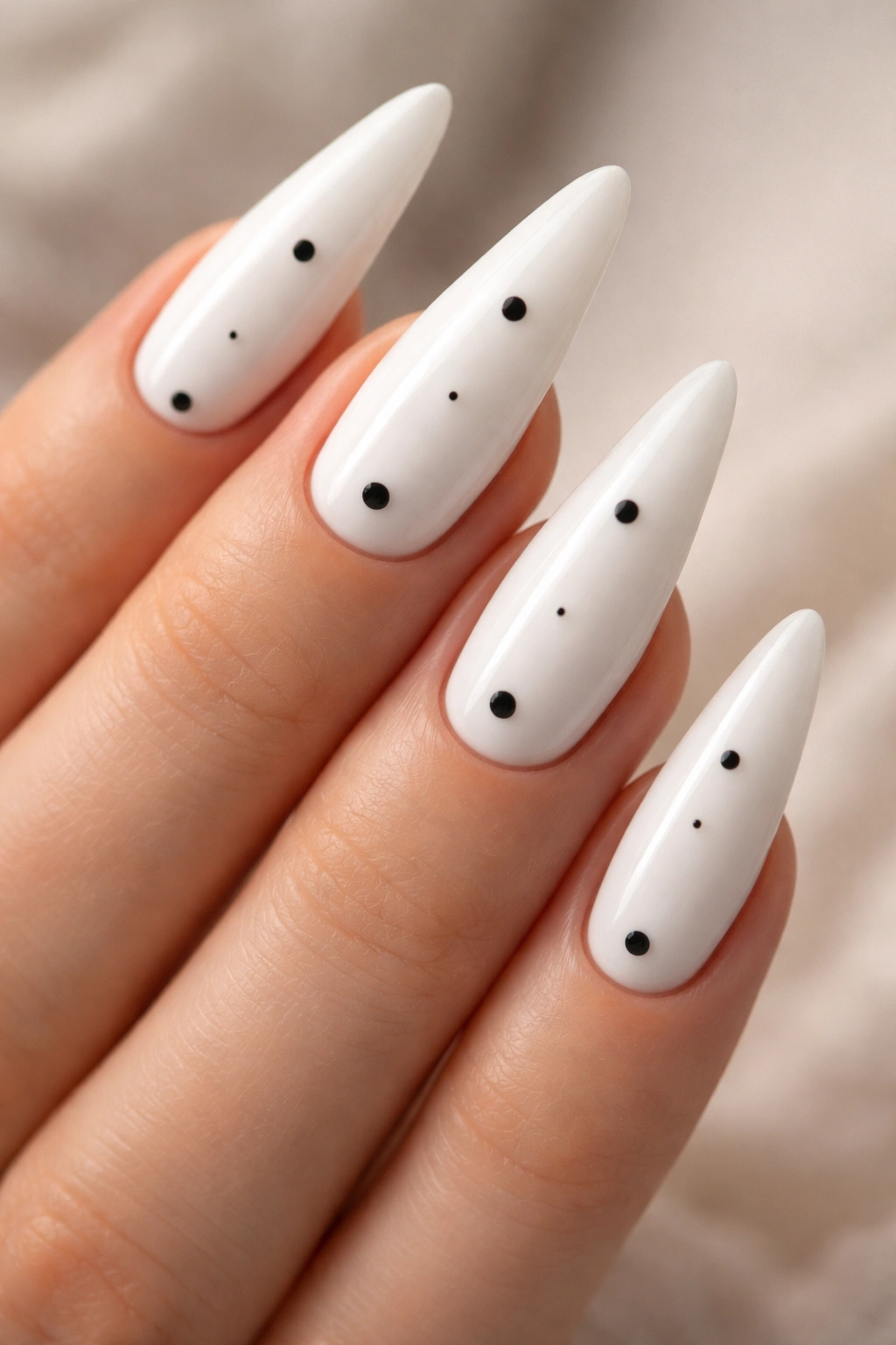 Stiletto nails with sparse black dots on white base