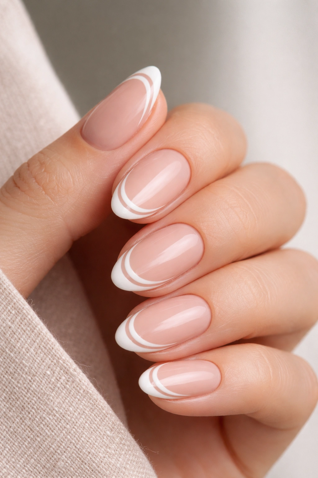 Close-up of nails with double French tips on a tiny almond nail