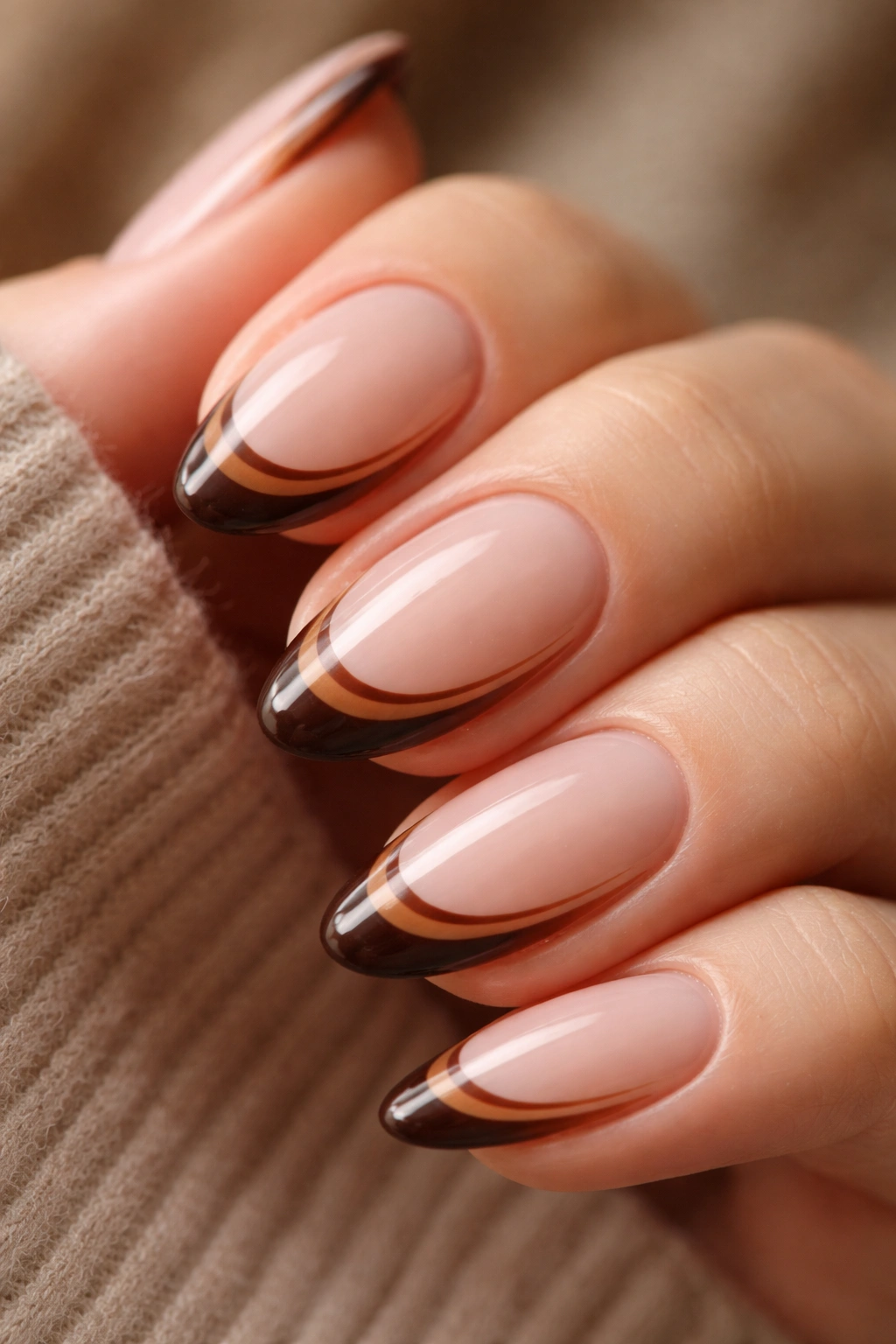 Close-up of a short almond nail with two parallel brown lines in the tip zone