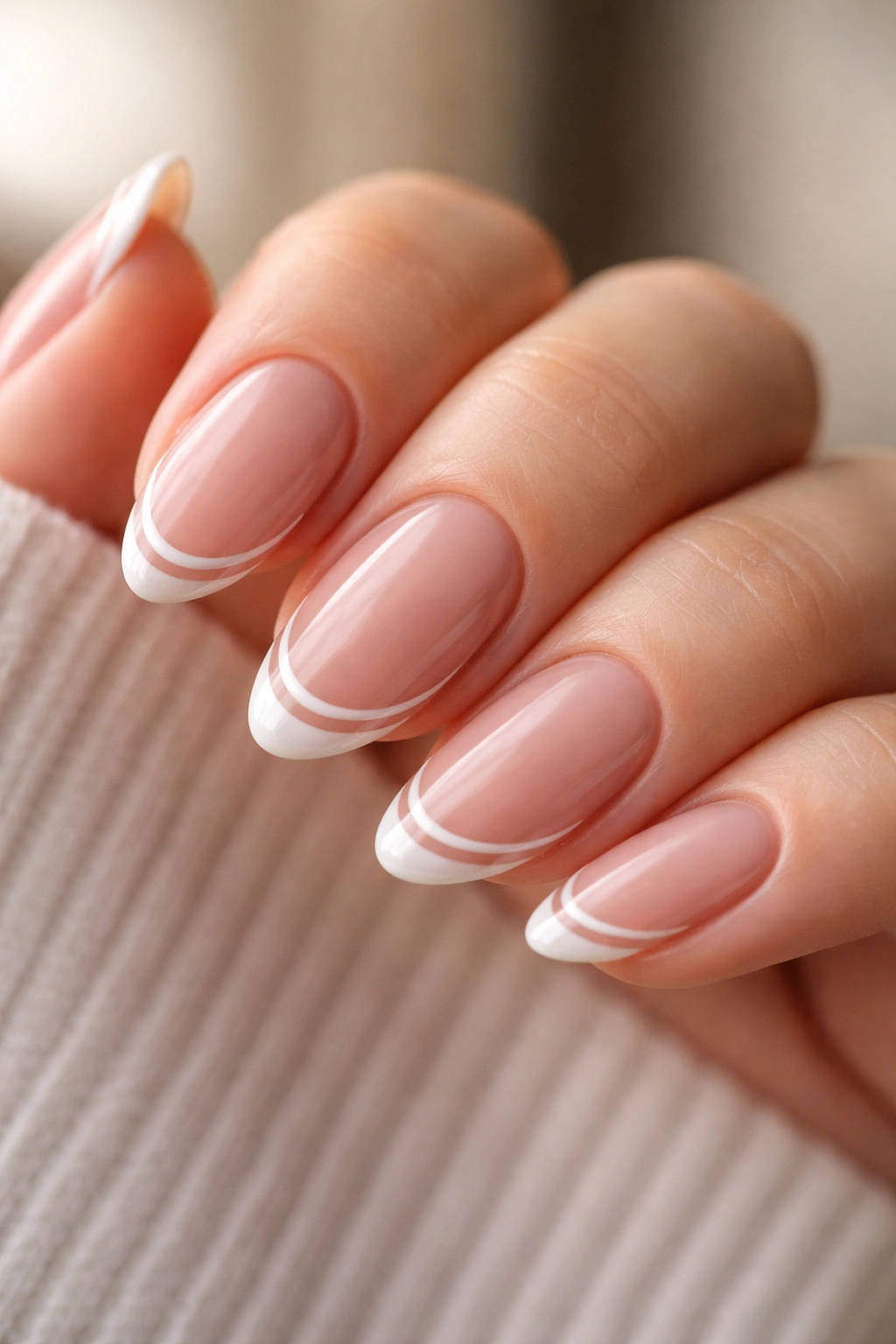 Close-up of short almond nails with two ultra-fine line French tips