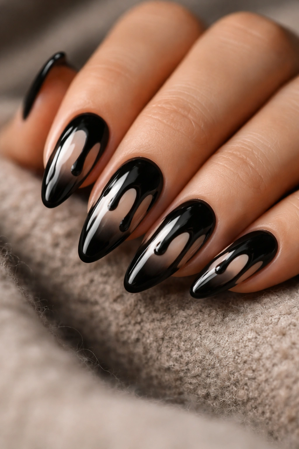 Almond nails with pale base and dripping black paint from tips