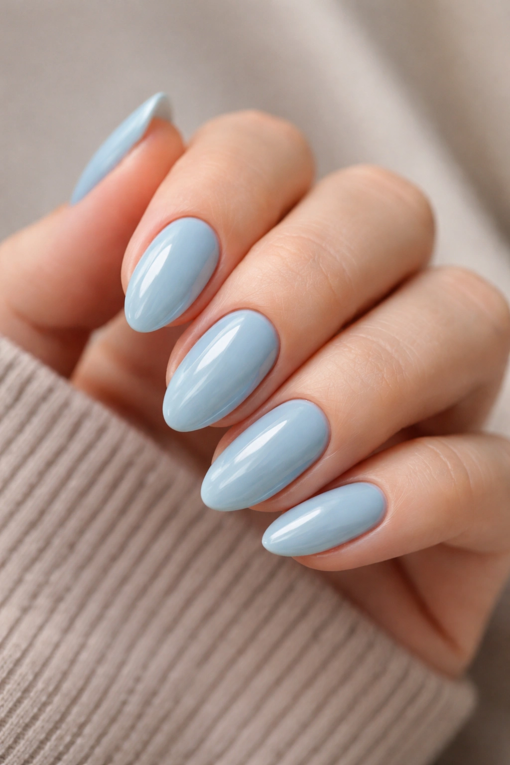 Close-up of short almond nails painted duck-egg blue with a glossy finish