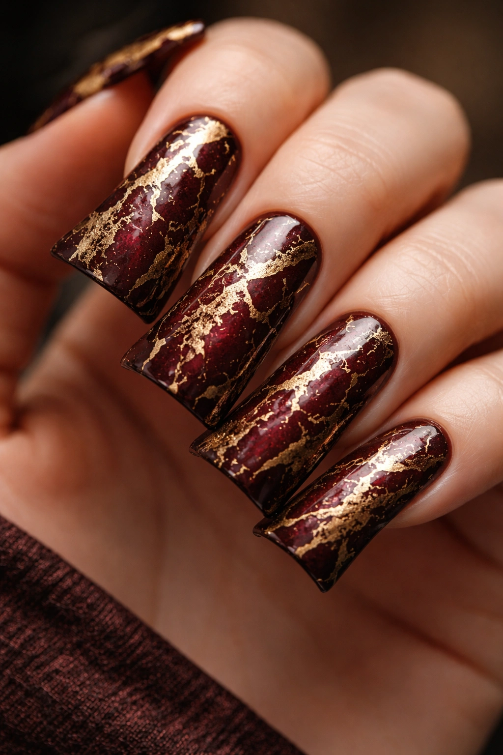 Duck nails in deep burgundy with gold crackle texture