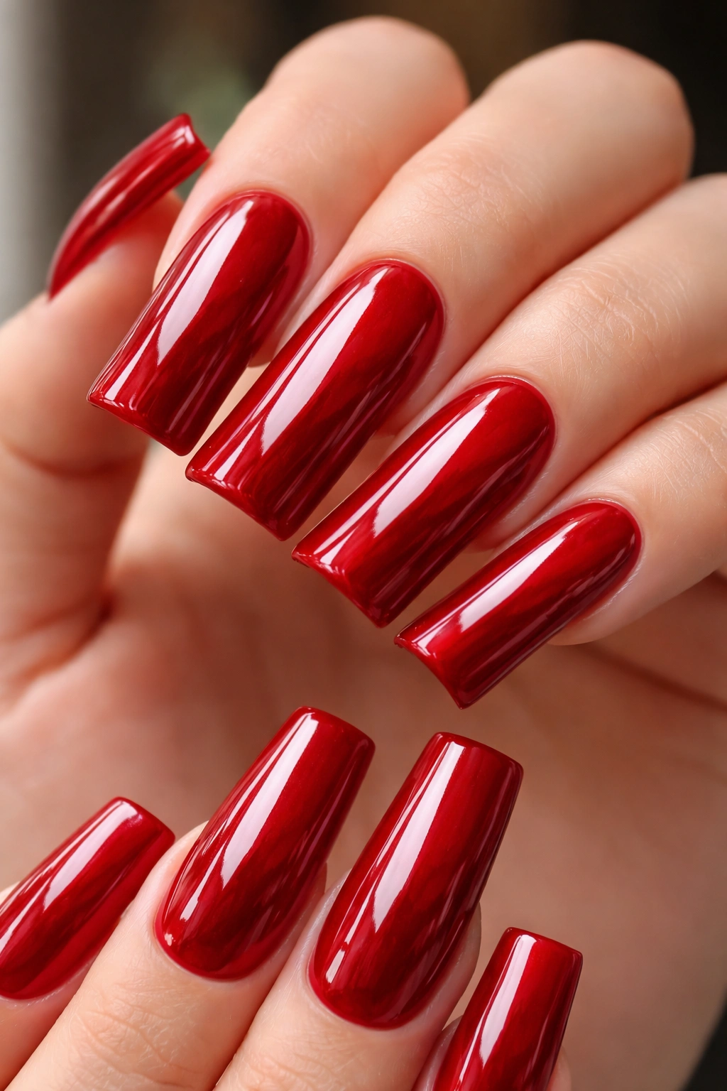 Close-up of duck nails in glossy cherry red with high shine