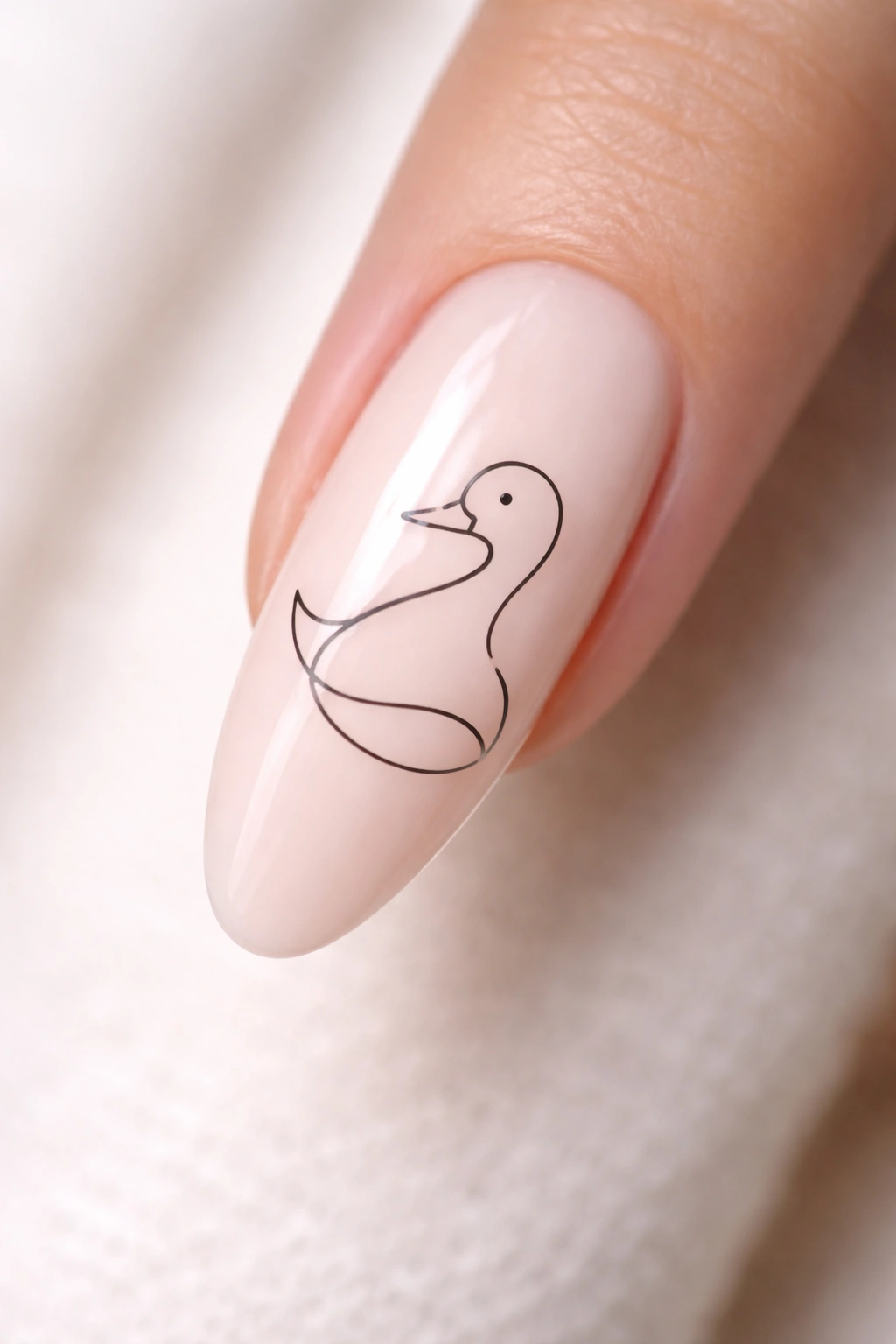 Close-up of a long nail featuring a minimalist line-art duck in a single black line
