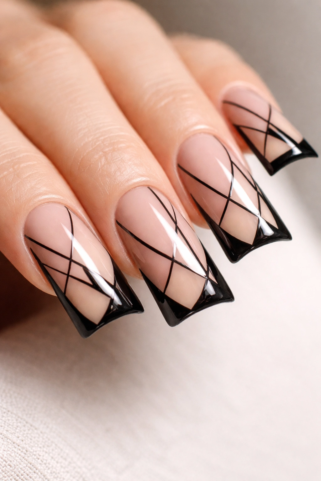Close-up of a duck nail with nude base and black negative-space pattern