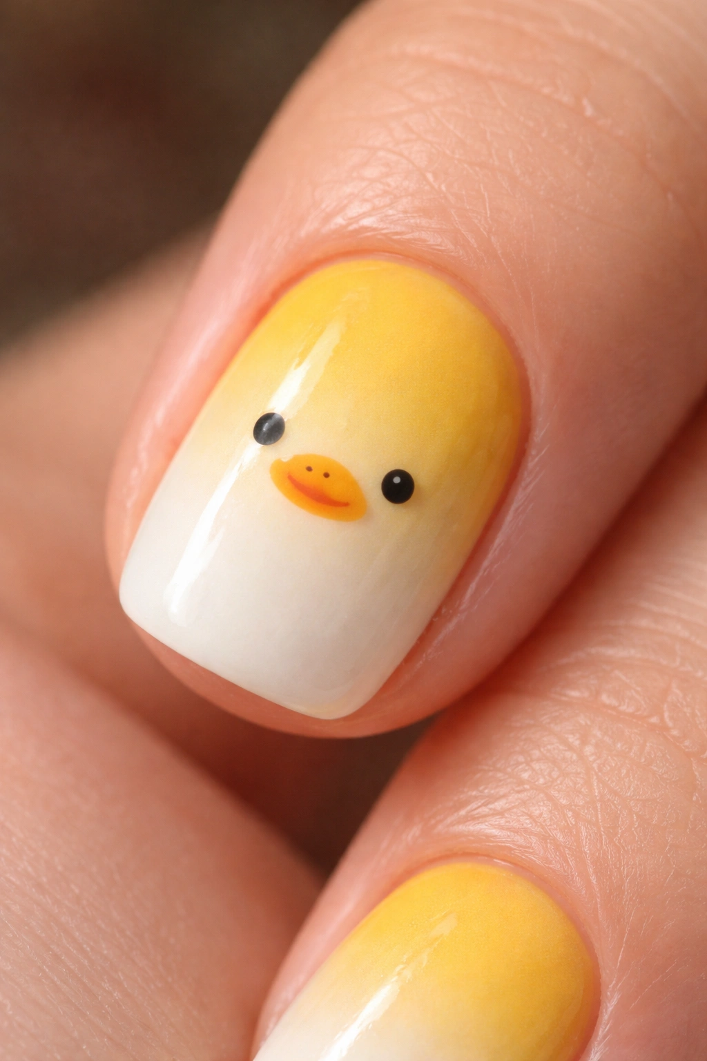 Short nail with yellow to white gradient and a small black duck face in the transition area.