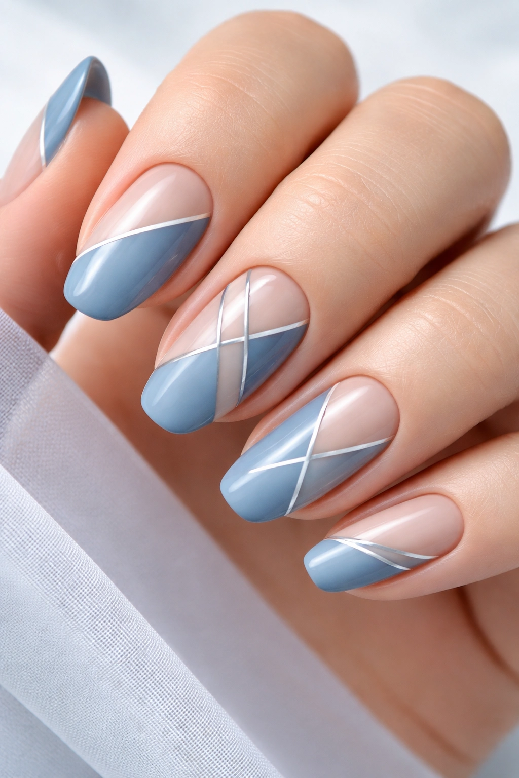Nails with dusty blue geometric patterns in close-up
