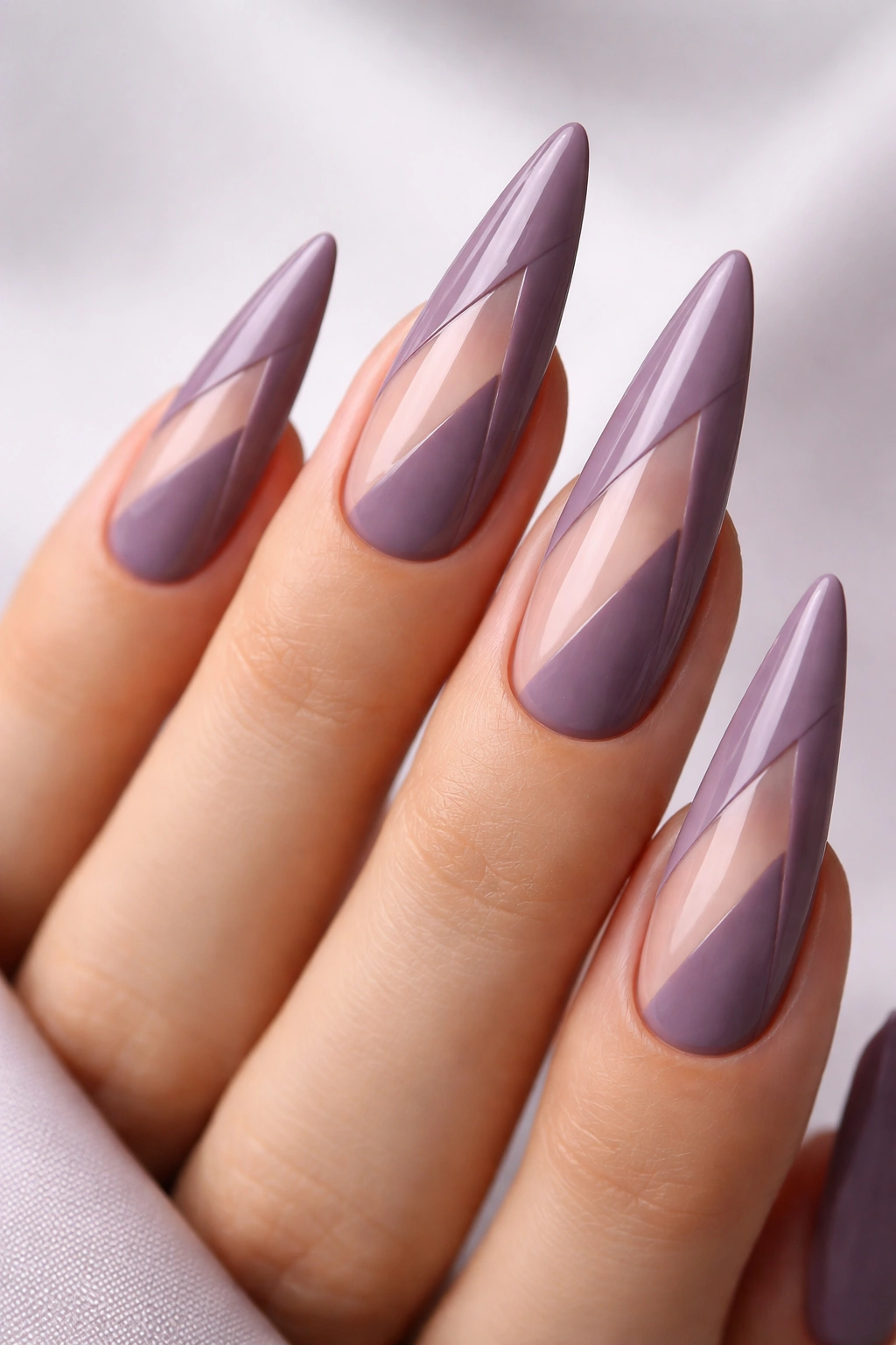 Close-up of dusty purple nails with negative space design on stiletto tips