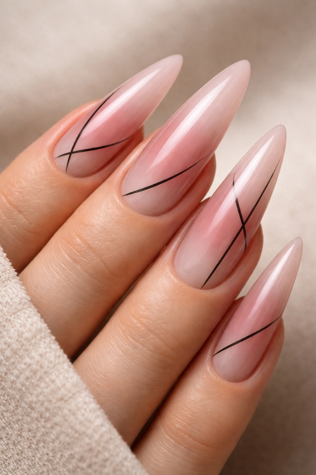 Dusty rose aura nails with minimalist black line work on stiletto shape
