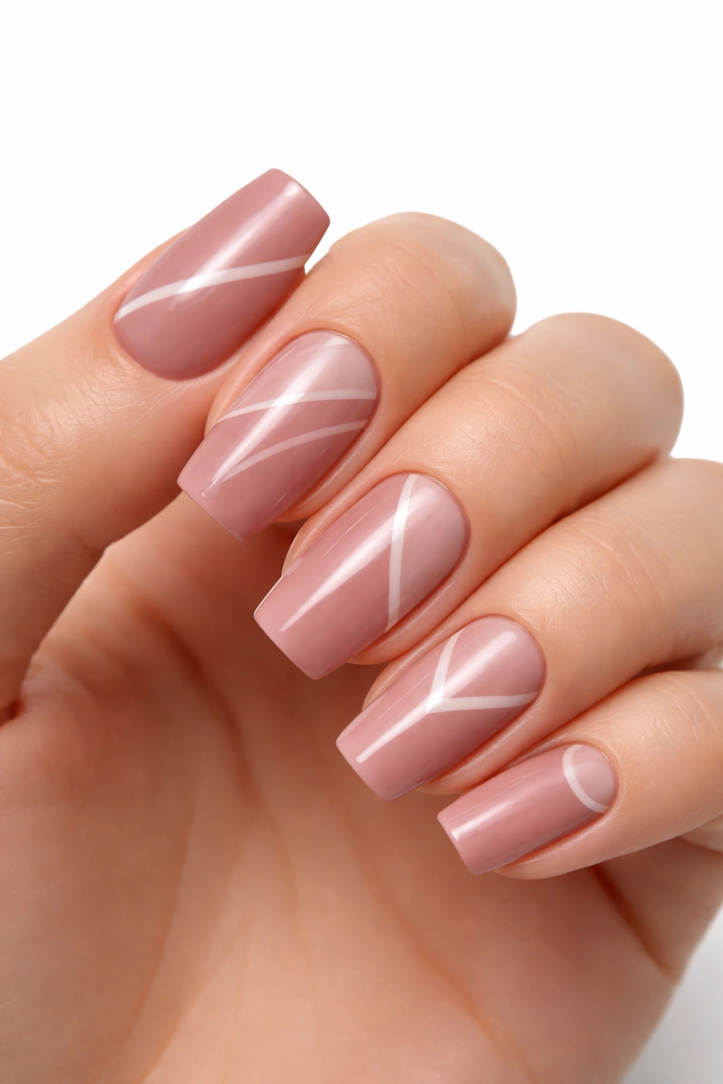 Dusty rose nails with negative space geometric patterns on soft square nails