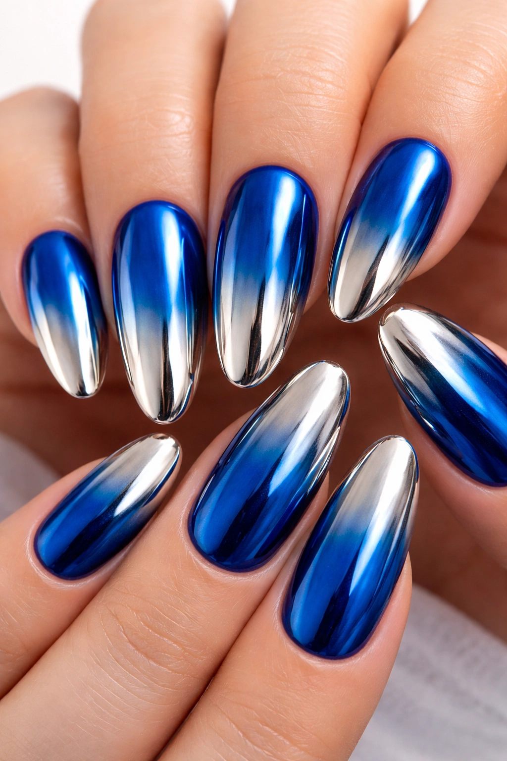 Close-up of electric blue chrome nails with reverse ombré on long oval nails