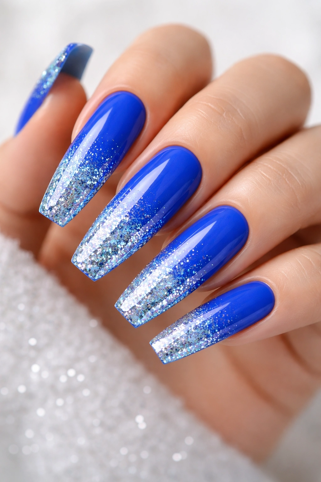 Electric blue coffin nails with glitter gradient at the tips